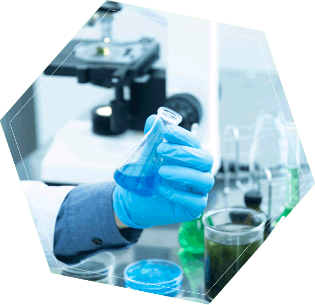 Investigador en laboratorio químico sosteniendo un matraz con líquido azul, microscopio y frascos en el fondo